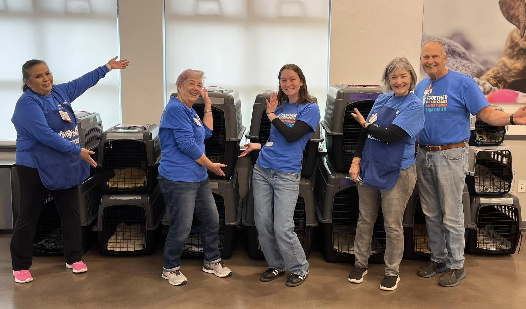 Volunteers standing in front of newly built pet crates. 